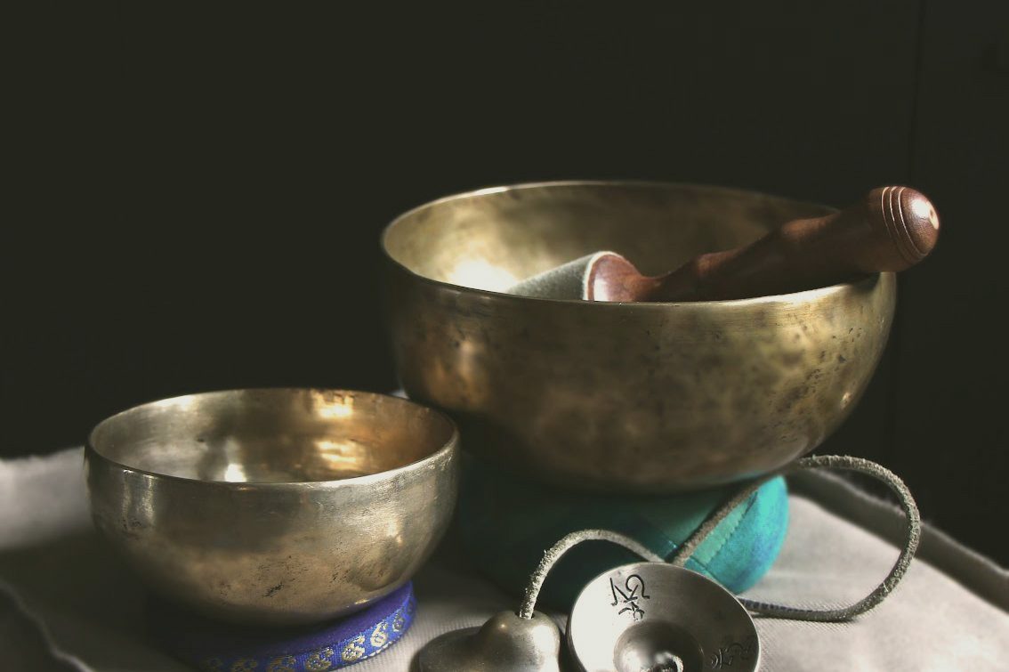 Workshops Twee klinkende metalen schalen en een stamper op een donkere achtergrond.